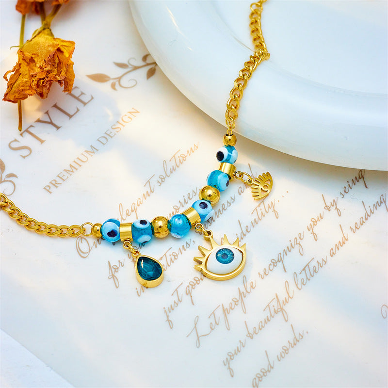 Bracciale alla moda con ciondolo a goccia asimmetrico a forma di occhio blu con perline in acciaio al titanio placcato per donne e uomini