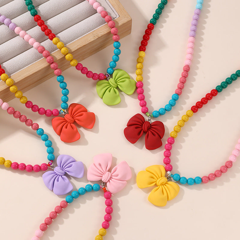 Lindo Collar de Resina con Forma de Lazo para Niñas con Acabado Pintado en Diseño Multicolor, Joyería Infantil Dulce y Juguetona