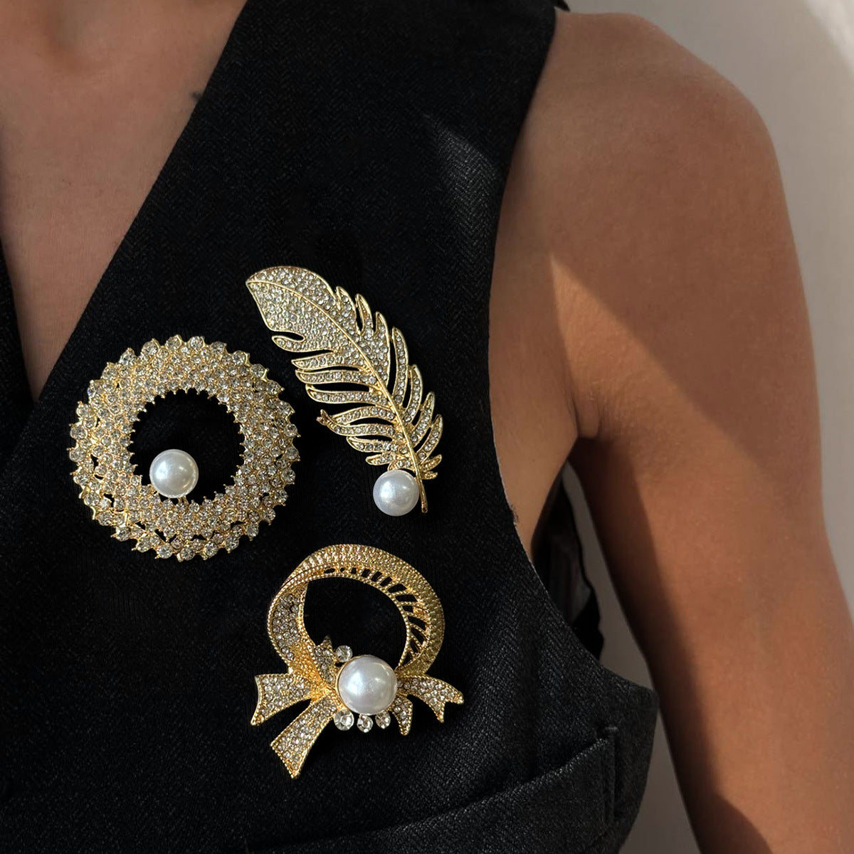 Elegante broche de lujo con incrustaciones de pedrería y detalles de perlas de imitación en base de aleación. Accesorio de moda en forma de pluma para mujer.