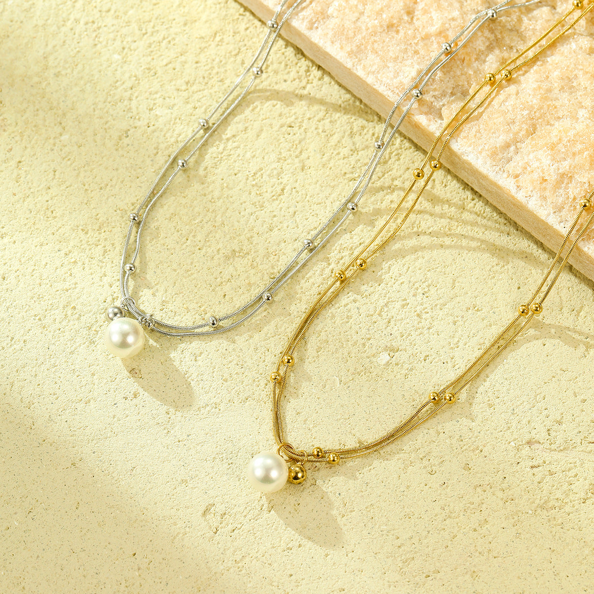 Collana minimalista con perle, doppia catena in acciaio al titanio e design con clavicola placcata in oro 18 carati