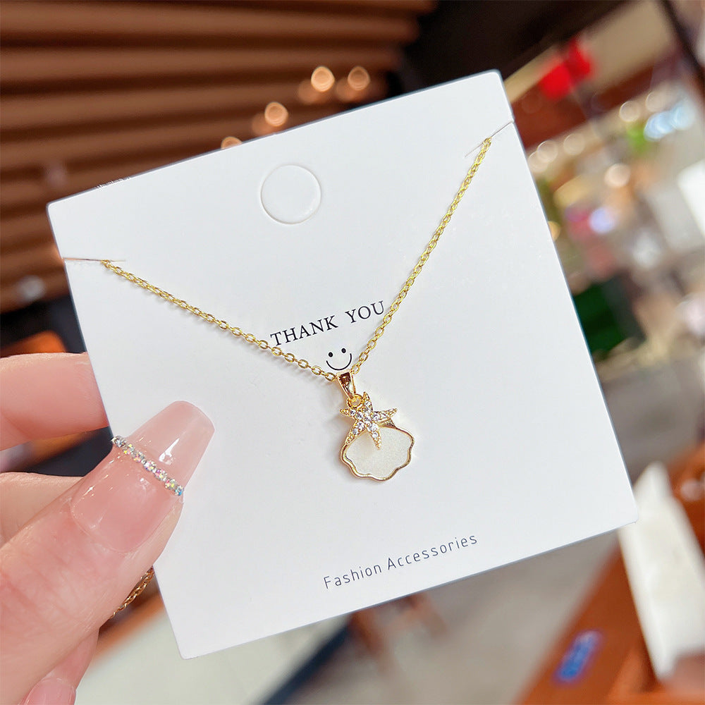 Collana da donna a catena a O in acciaio al titanio con stelle marine e conchiglie, finitura placcata e design minimalista