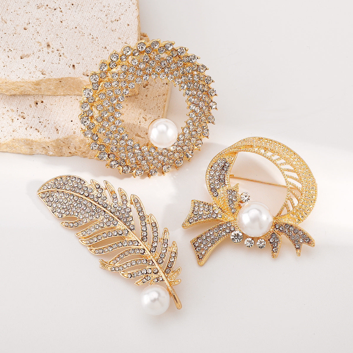 Elegante broche de lujo con incrustaciones de pedrería y detalles de perlas de imitación en base de aleación. Accesorio de moda en forma de pluma para mujer.