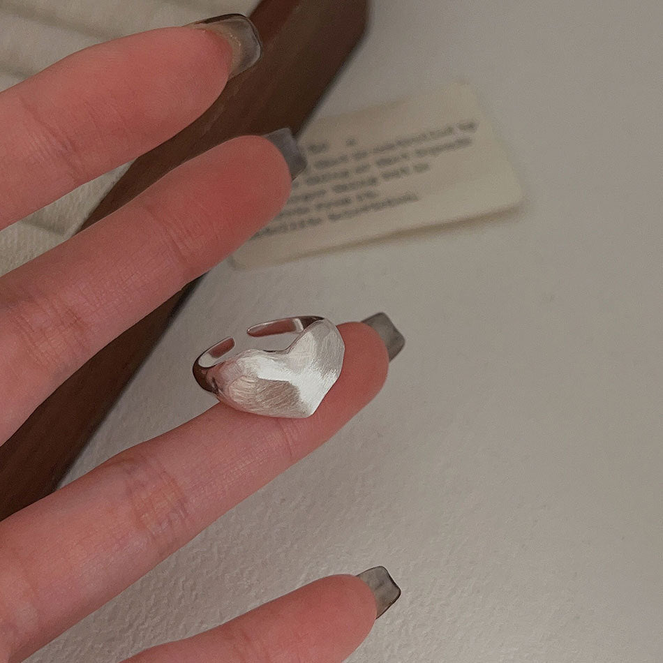 Anillo minimalista de plata de ley 925 con forma de corazón, acabado pulido y detalle de grano cuadrado biselado