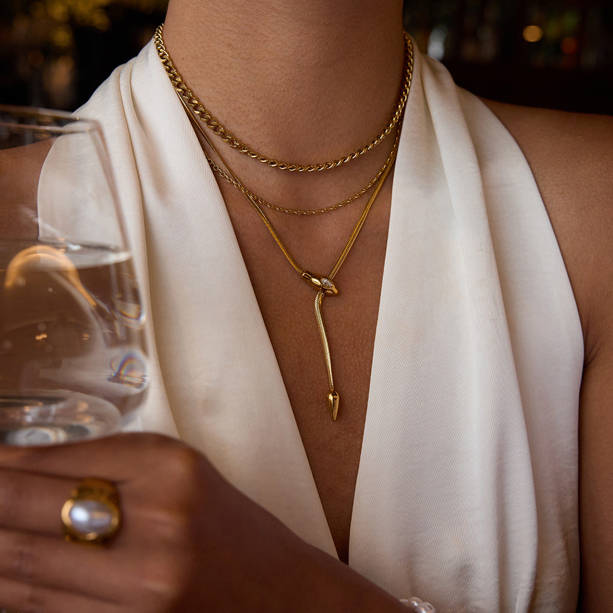 Collana con ciondolo a serpente geometrico in acciaio al titanio con intarsio di strass e finitura placcata per donna