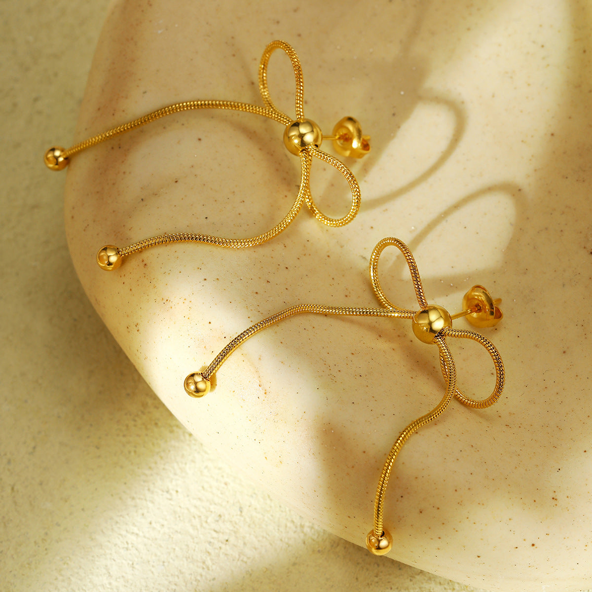 Orecchini da donna in acciaio inossidabile a forma di fiocco, placcati in oro 18 carati e rifiniti in acciaio al titanio, alla moda