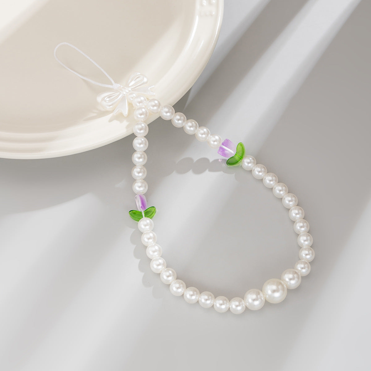 Bonita correa de teléfono con nudo de lazo de tulipán y perlas de imitación para mujeres, accesorio tejido a mano con dulce estilo floral