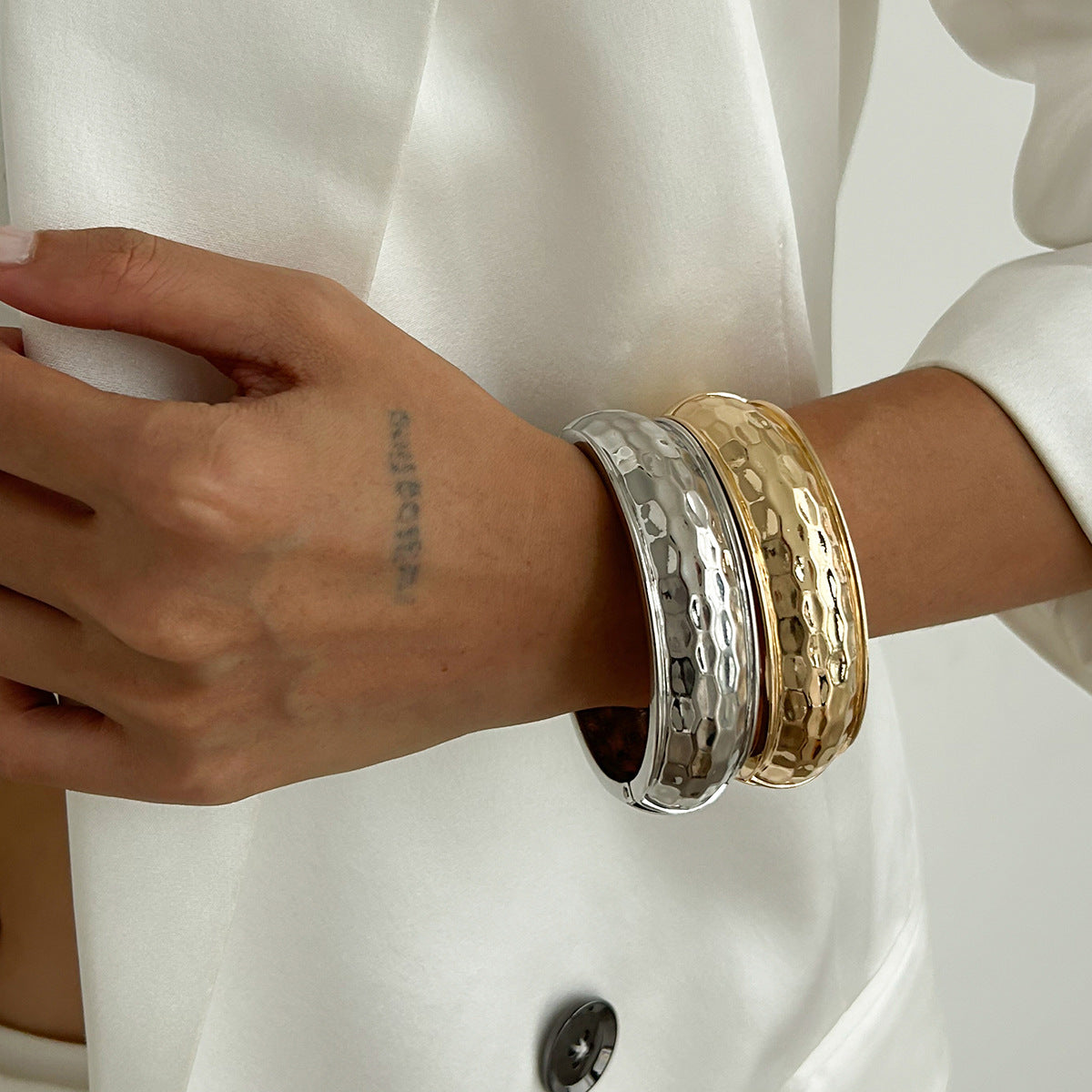 Bracciale rigido aperto da donna minimalista geometrico con texture martellata e chiusura a molla