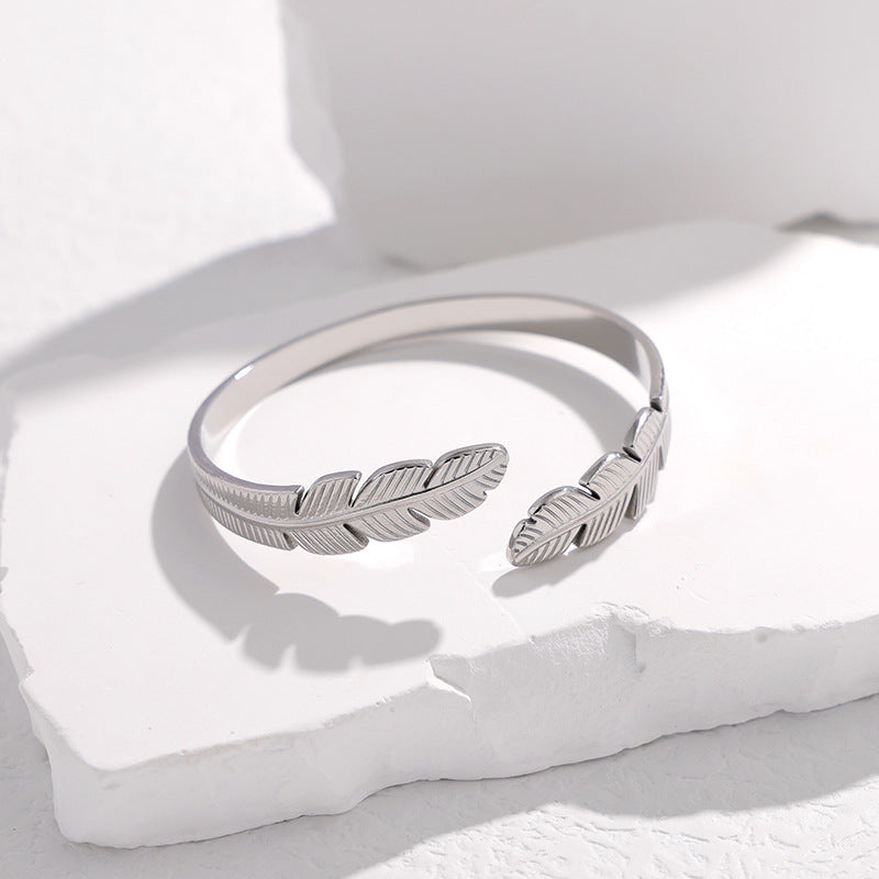 Bracciale a fascia in acciaio al titanio a forma di piuma, minimalista, da donna, con finitura placcata e design aperto regolabile