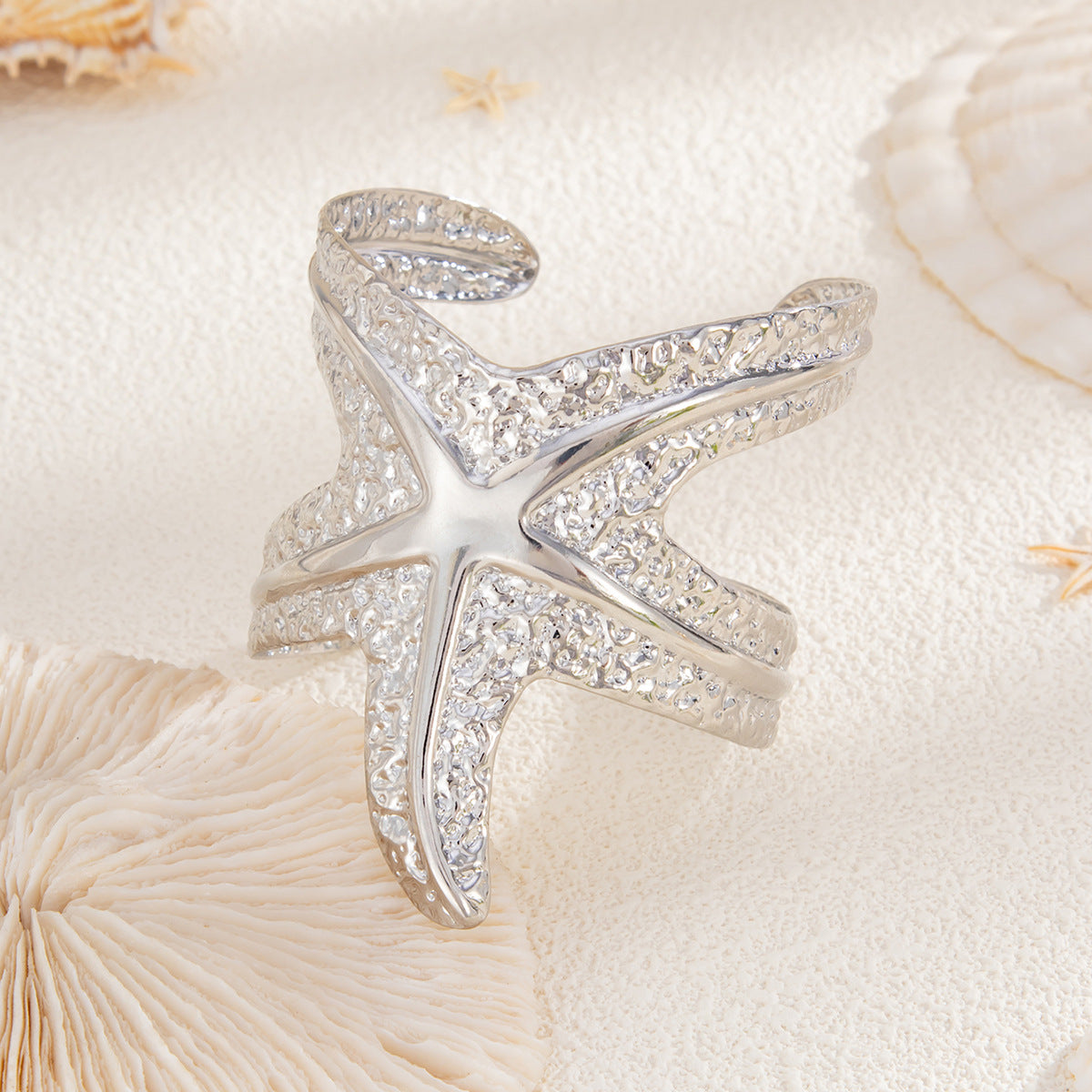 Pulsera metálica con forma de estrella de mar exagerada y acabado galvanizado para un estilo playero y oceánico