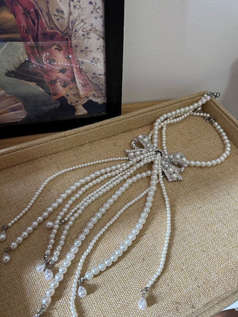 Elegante collar con colgante de lazo de diamantes de imitación de estilo francés en aleación con detalles de perlas de imitación, delicada cadena para la clavícula para mujer