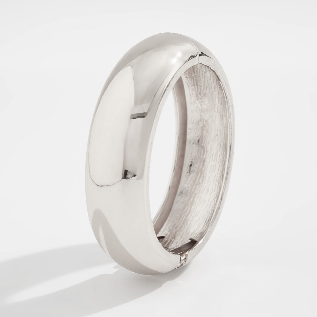 Bracciale rigido da donna in metallo audace con design geometrico, superficie lucida e finitura placcata