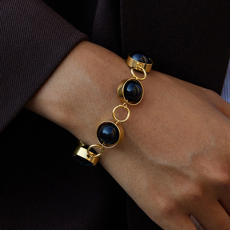 Bracciale minimalista geometrico girevole con chiusura a T in perline di vetro nero e acciaio al titanio con finitura placcata