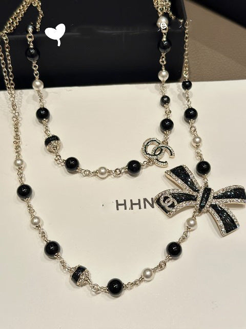 Elegante set di collana e orecchini in ottone placcato oro con fiocco smaltato da donna