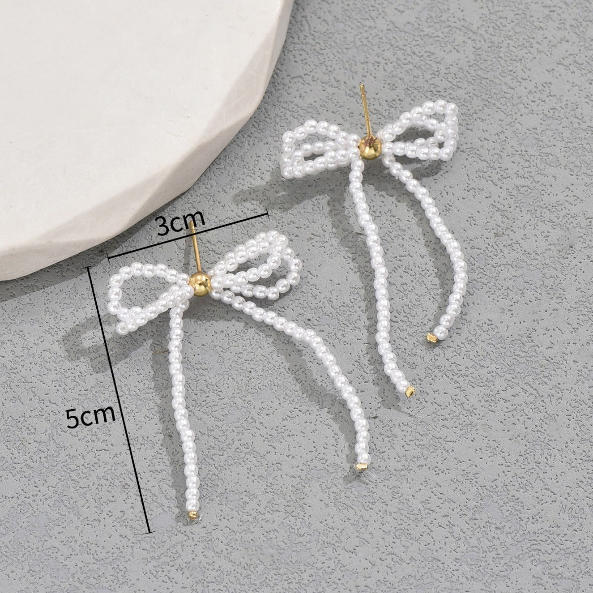 Orecchini a perno alla moda in lega a forma di fiocco con intarsio di perle per donne, polsini auricolari a doppio strato con design vuoto