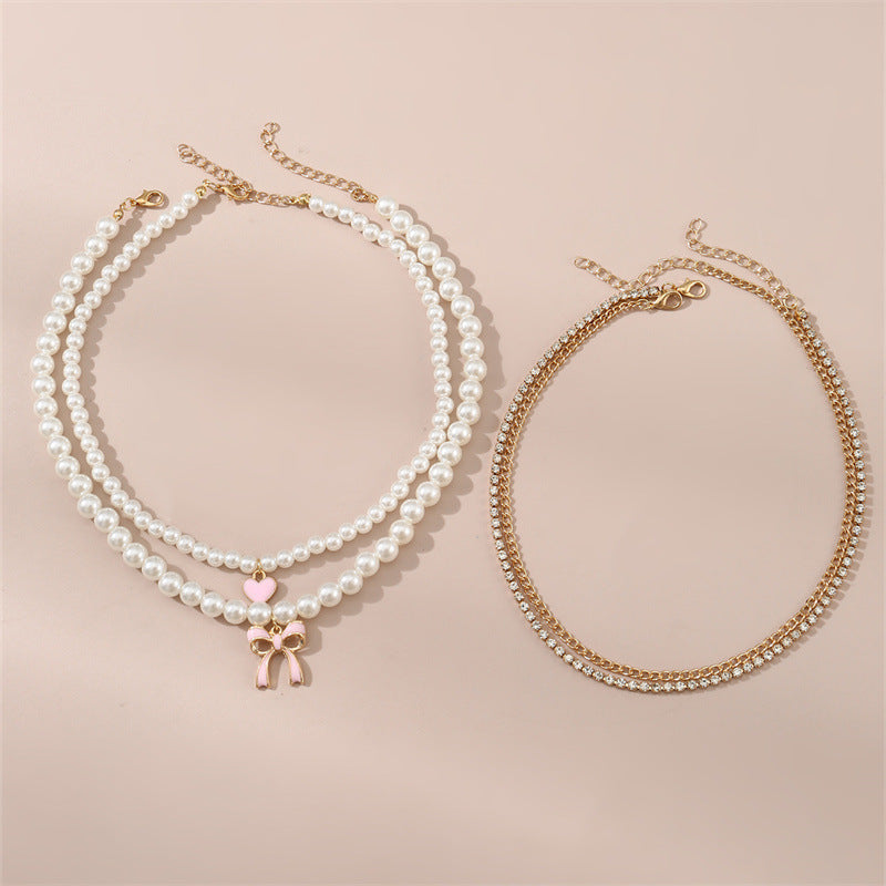 Set di collana con ciondolo a fiocco e cuore stile dolce per bambini con accenti di perle e perline infilate a mano su catena in resina