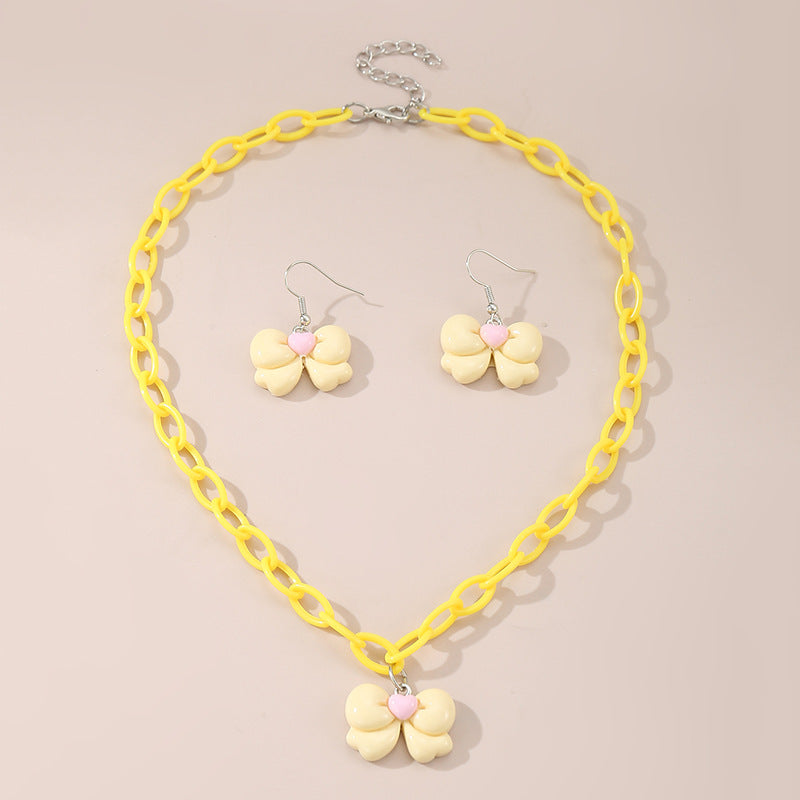 Collar con colgante de lazo acrílico minimalista color caramelo para niños con acabado esmaltado y cadena de cuentas