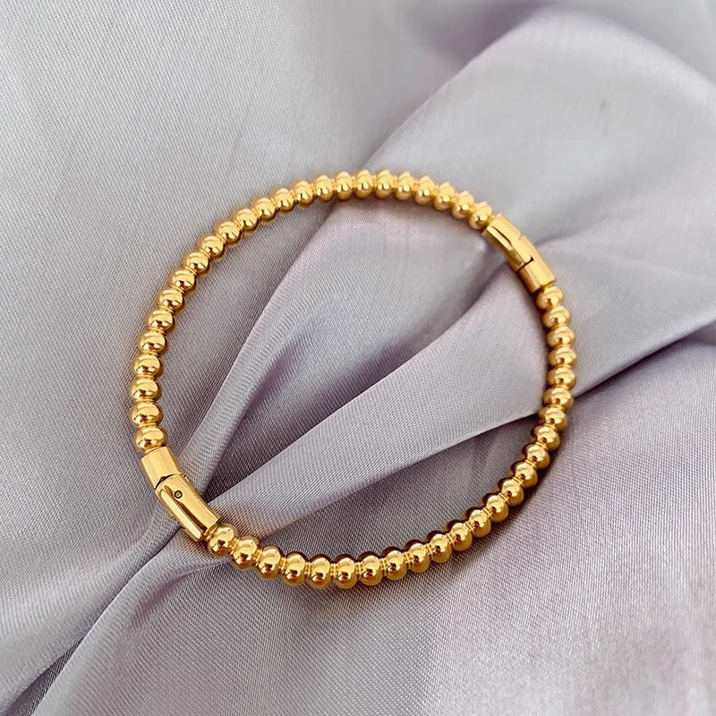 Bracciale minimalista da donna in acciaio al titanio color oro con perline rotonde lucide