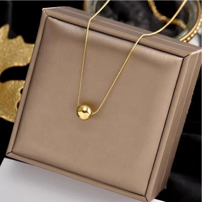 Collana da donna minimalista con pendente a sfera in acciaio al titanio con placcatura in oro e catena a serpente