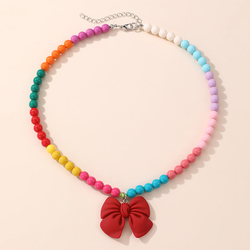Lindo Collar de Resina con Forma de Lazo para Niñas con Acabado Pintado en Diseño Multicolor, Joyería Infantil Dulce y Juguetona