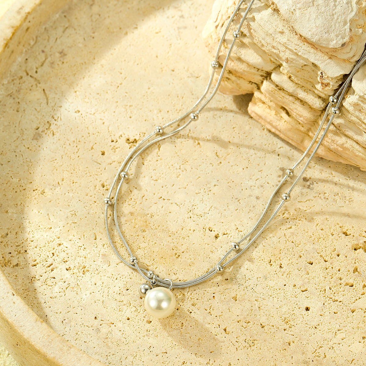 Collana minimalista con perle, doppia catena in acciaio al titanio e design con clavicola placcata in oro 18 carati