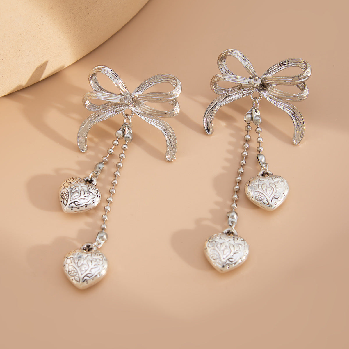 Pendientes largos minimalistas con borlas en forma de corazón y detalle de lazo en aleación chapada para mujer