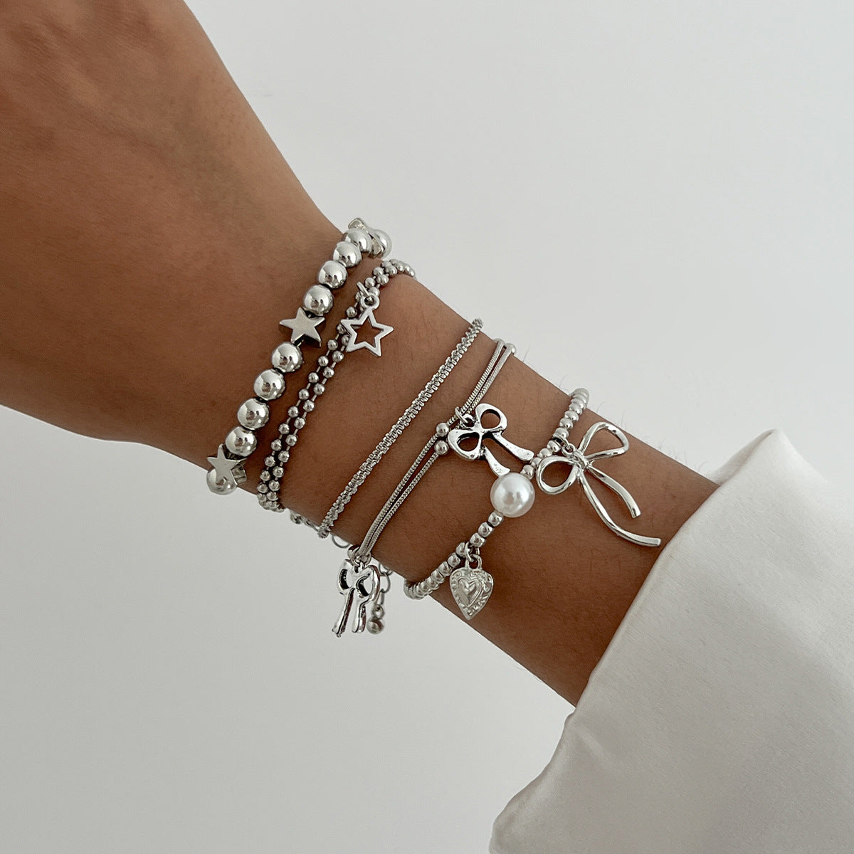 Minimalist Bow Knot and Star-Shaped Pendant Bracelet for Women with Plated Metal and Imitation Pearl Accents