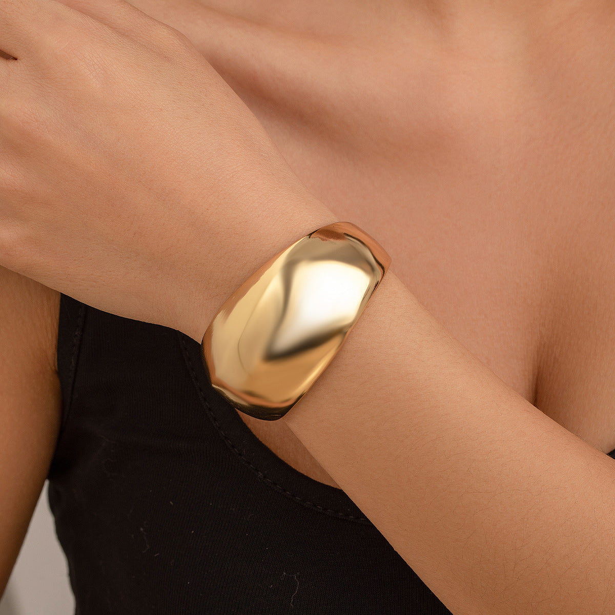 Bracciale rigido da donna in metallo audace con design geometrico, superficie lucida e finitura placcata