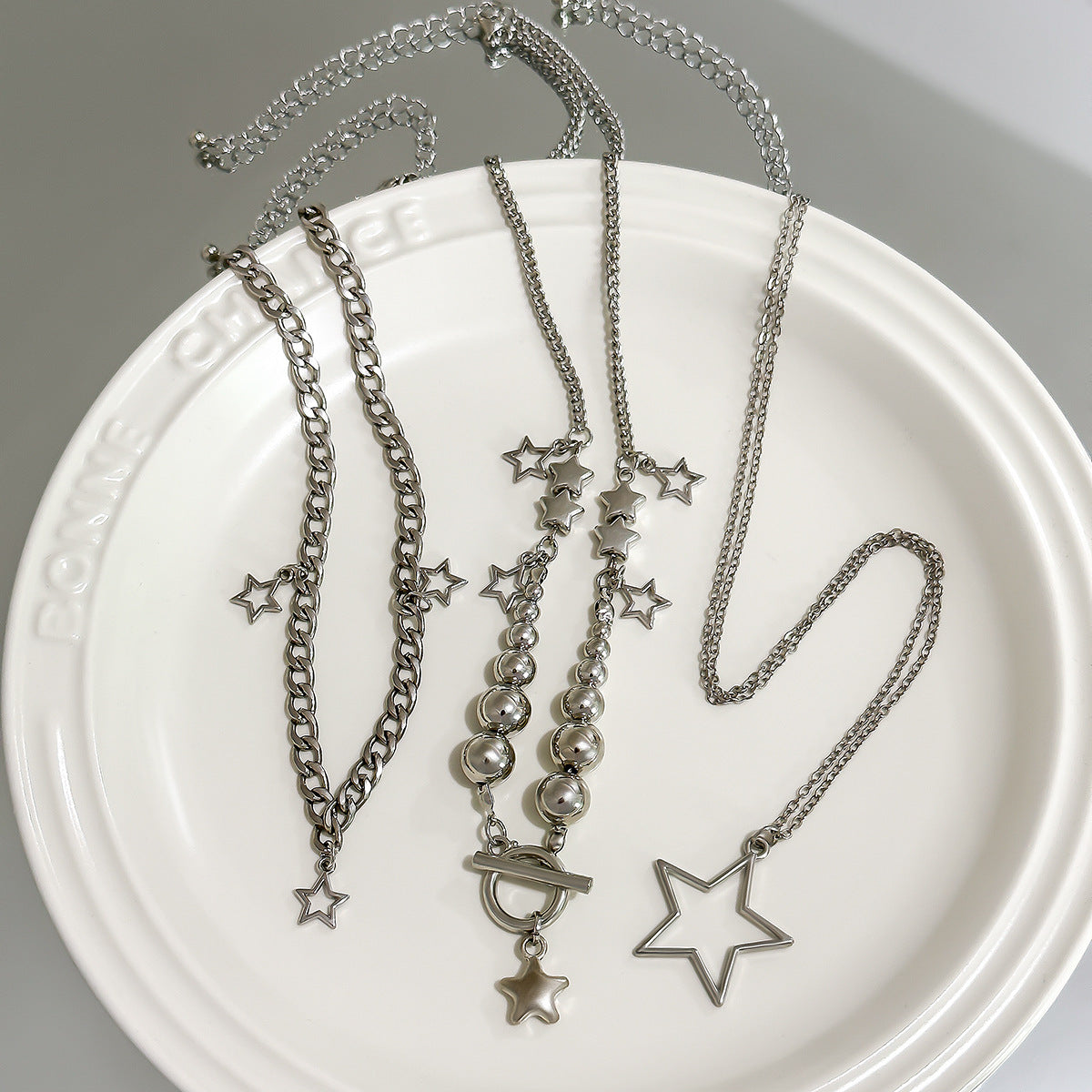 Collana pendente a forma di stella tagliente con nappe da donna, con struttura in lega di zinco e finitura galvanizzata su catenina a sfere