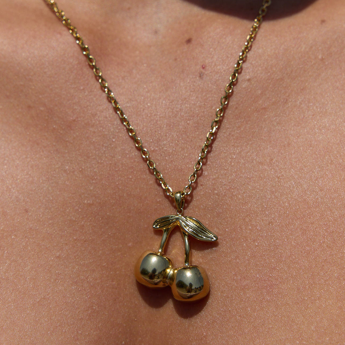 Collana da donna con ciondolo geometrico a ciliegia in acciaio al titanio placcato oro 18 carati