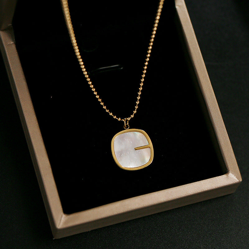 Collana da donna con pendente a G geometrico minimalista in madreperla, catena in acciaio al titanio e finitura placcata