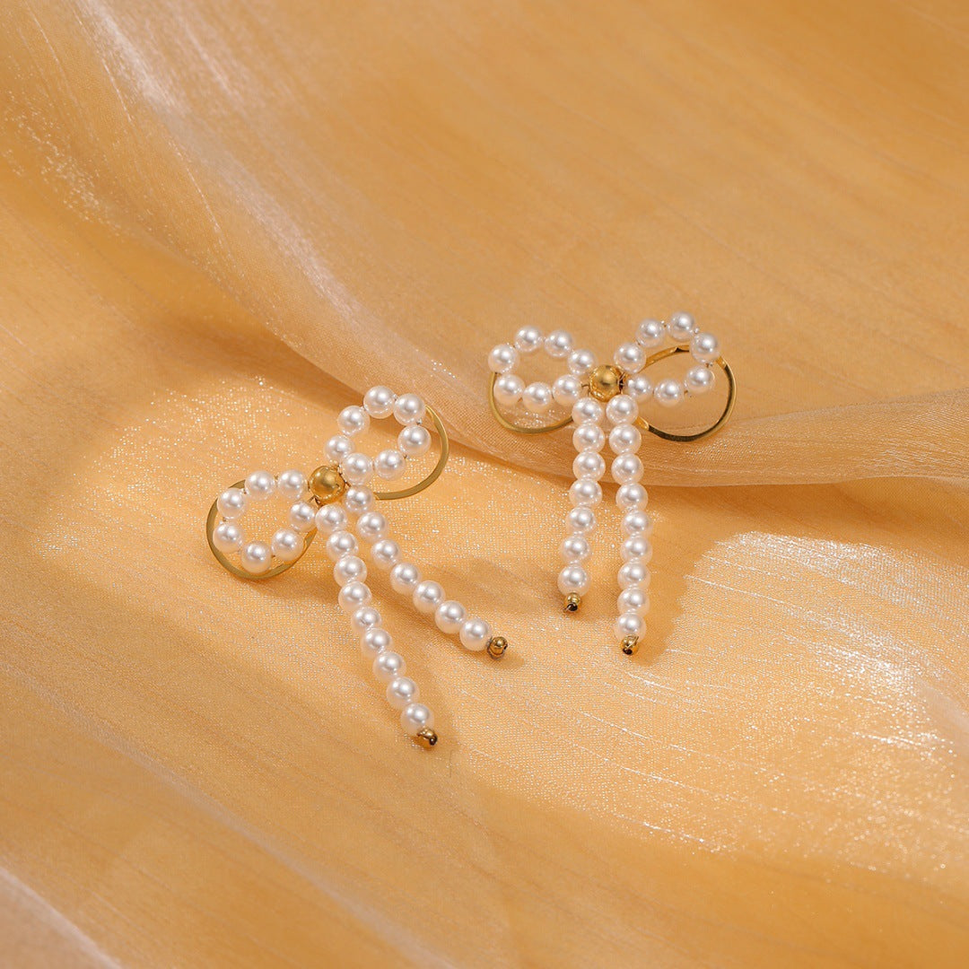 Orecchini da donna minimalisti con fiocco in perle e acciaio al titanio, con finitura placcata e design a forma di cuore