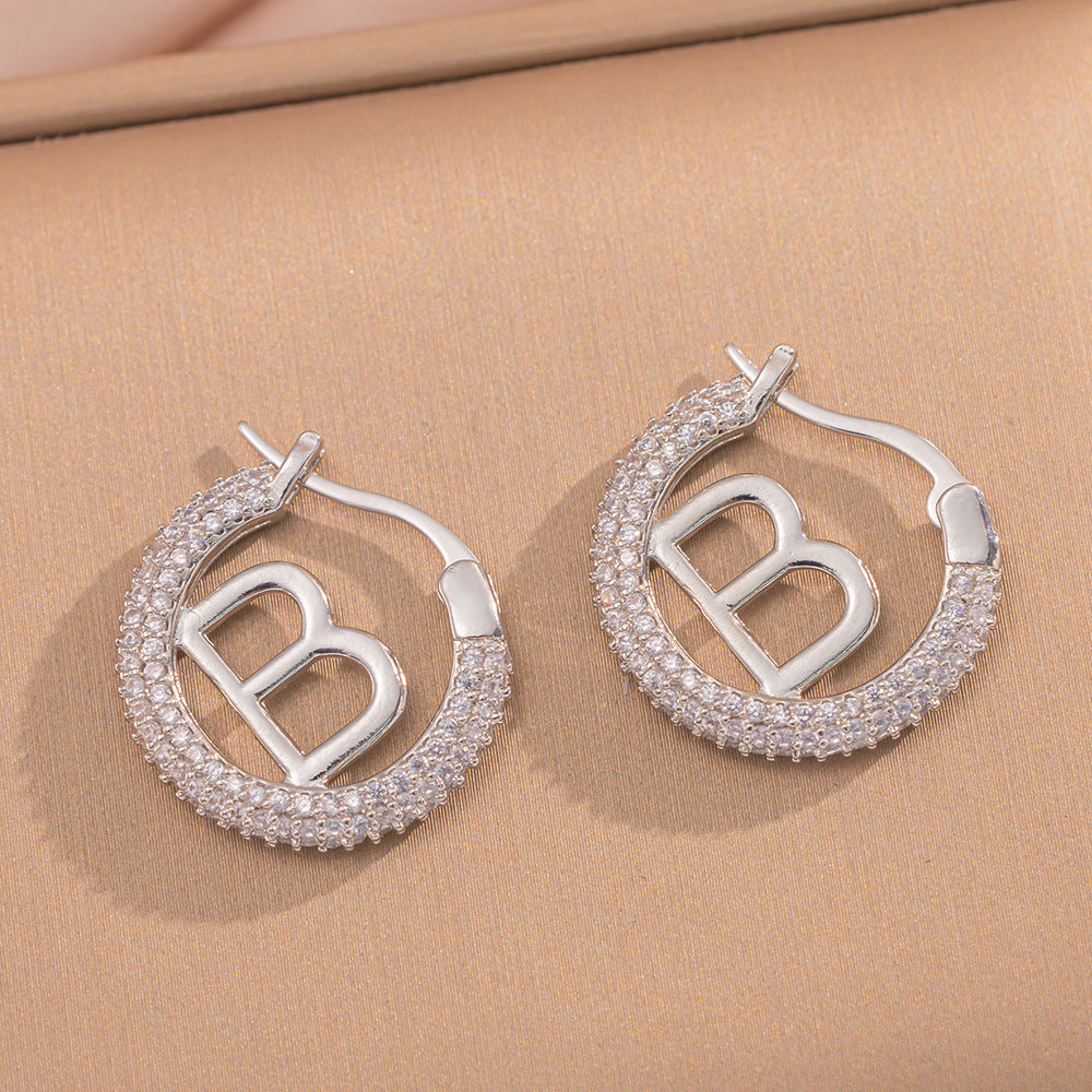 Orecchini a perno Saturno minimalisti color oro in ottone con zirconi per donna