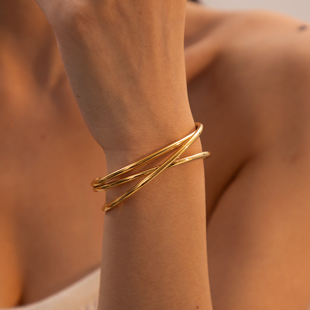 Pulsera de acero titanio con textura geométrica estilo INS para mujer, con baño de oro de 18K y diseño de brazalete abierto.