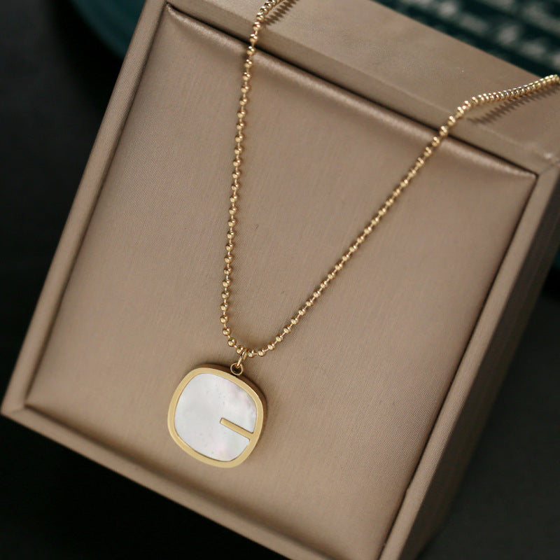 Collana da donna con pendente a G geometrico minimalista in madreperla, catena in acciaio al titanio e finitura placcata