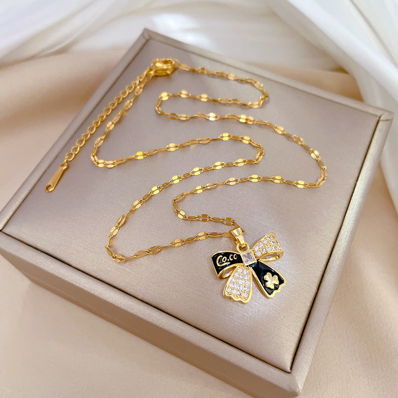 Collana con ciondolo a fiocco in stile cartone animato, motivo floreale, in acciaio al titanio con intarsio di strass, per donna
