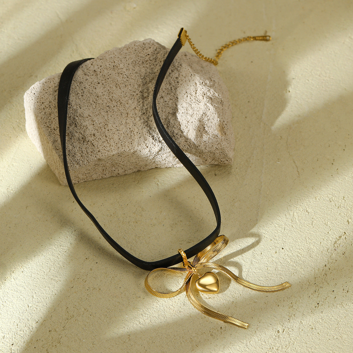 Collar minimalista de acero de titanio en forma de lazo para mujer con acabado chapado y detalle de cuero