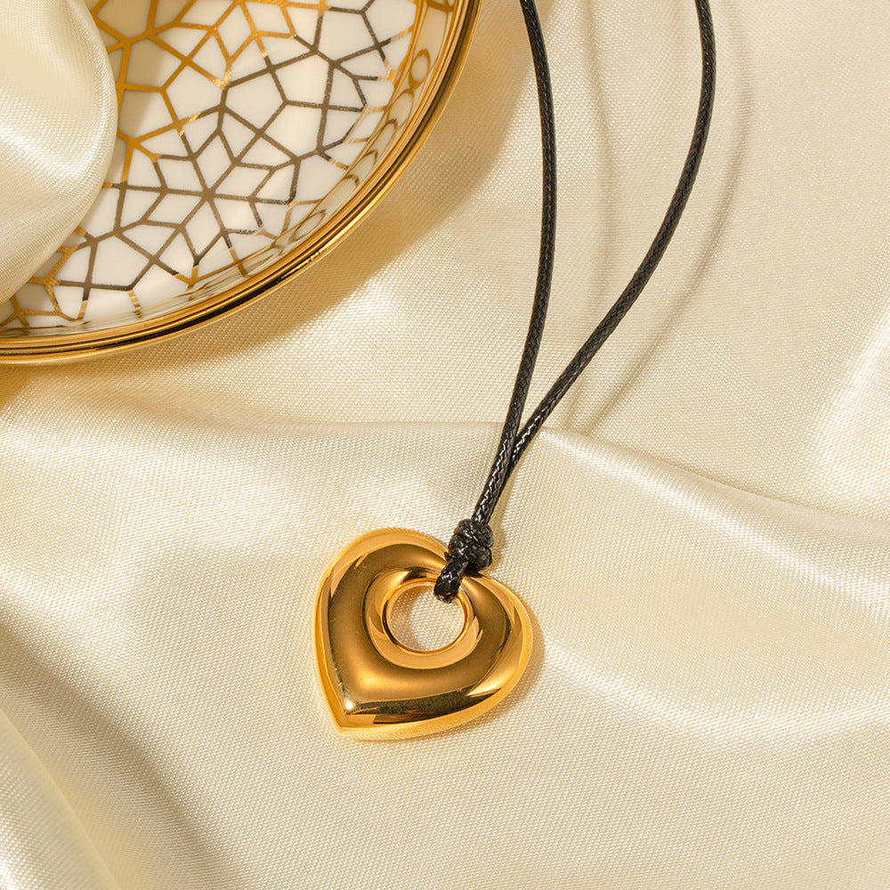 Collar con colgante de corazón hueco minimalista de acero inoxidable con cordón de cera negro y acabado chapado