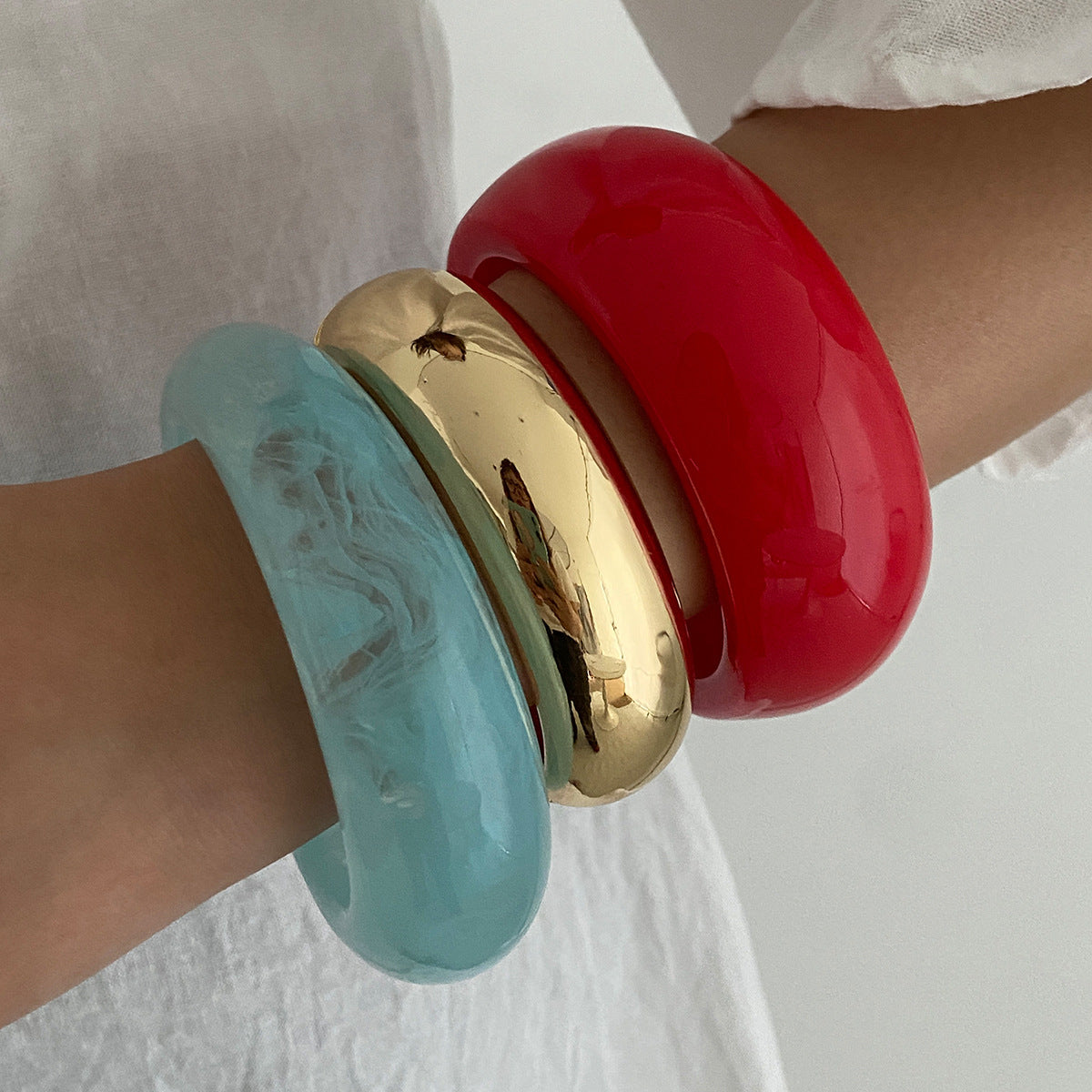 Pulsera geométrica en contraste rojo vivo con acabado pulido y superficie galvanizada para mujer