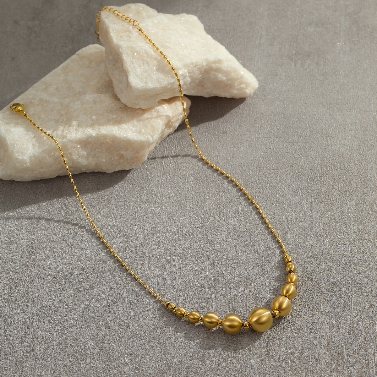 Collana da donna alla moda con perline a occhio di gatto in acciaio al titanio spazzolato con pendente geometrico placcato in oro 18 carati e delicata catena clavicolare