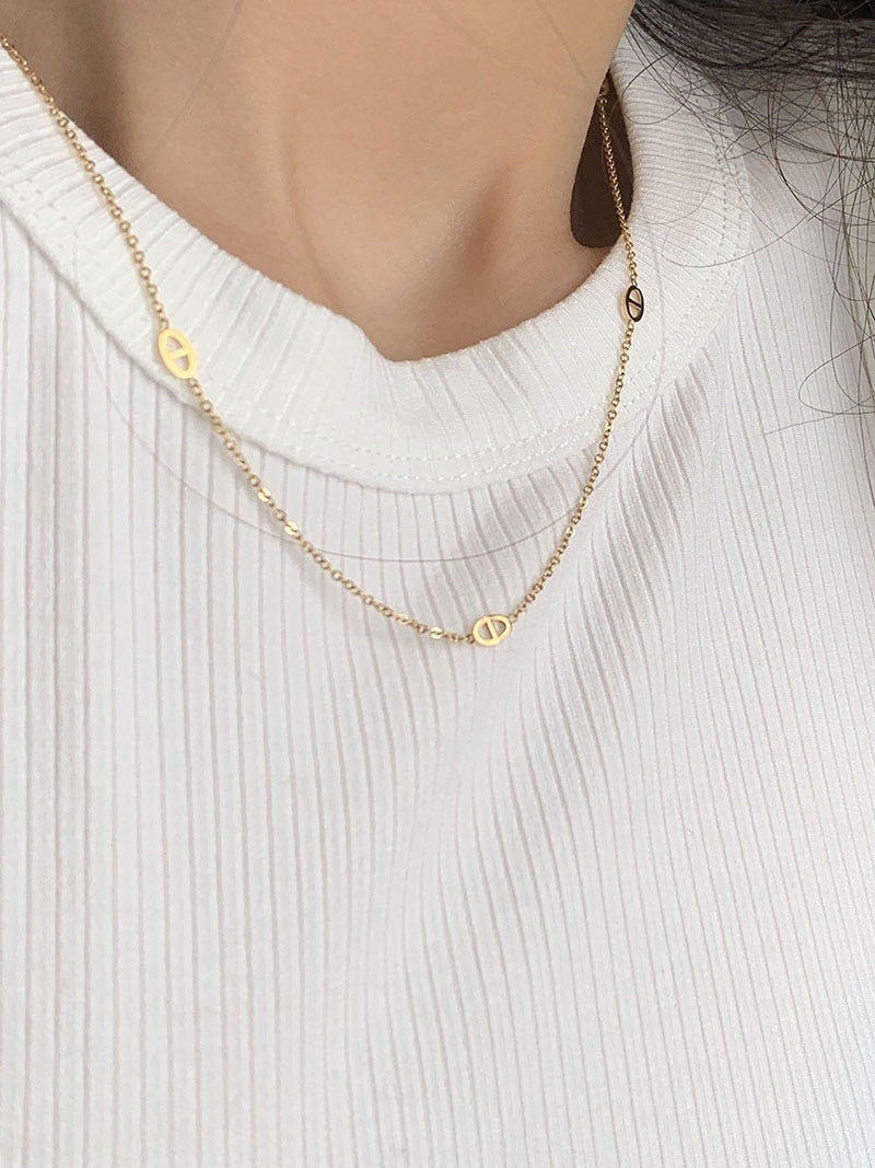 Collana con pendente a naso di maiale in acciaio al titanio placcato oro, tono freddo e minimalista, da donna, con catena a O e design che esalta le clavicole