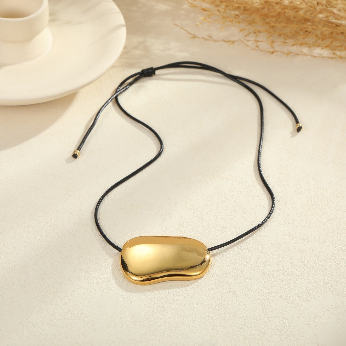 Collana con ciondolo geometrico minimalista in acciaio al titanio con cordino nero e finitura galvanizzata da donna