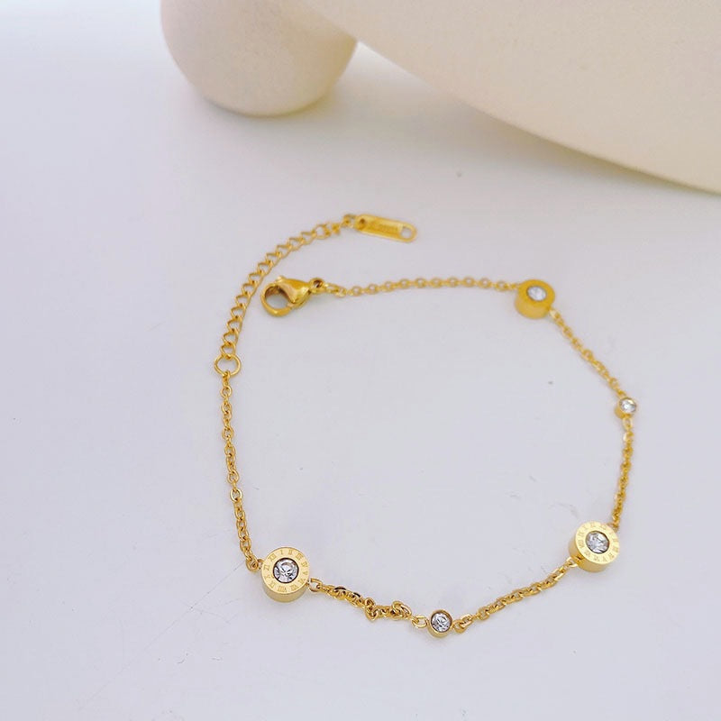 Bracciale Minimalista da Donna in Acciaio al Titanio con Lettere Romane, Intarsio di Strass e Placcatura in Oro 18K