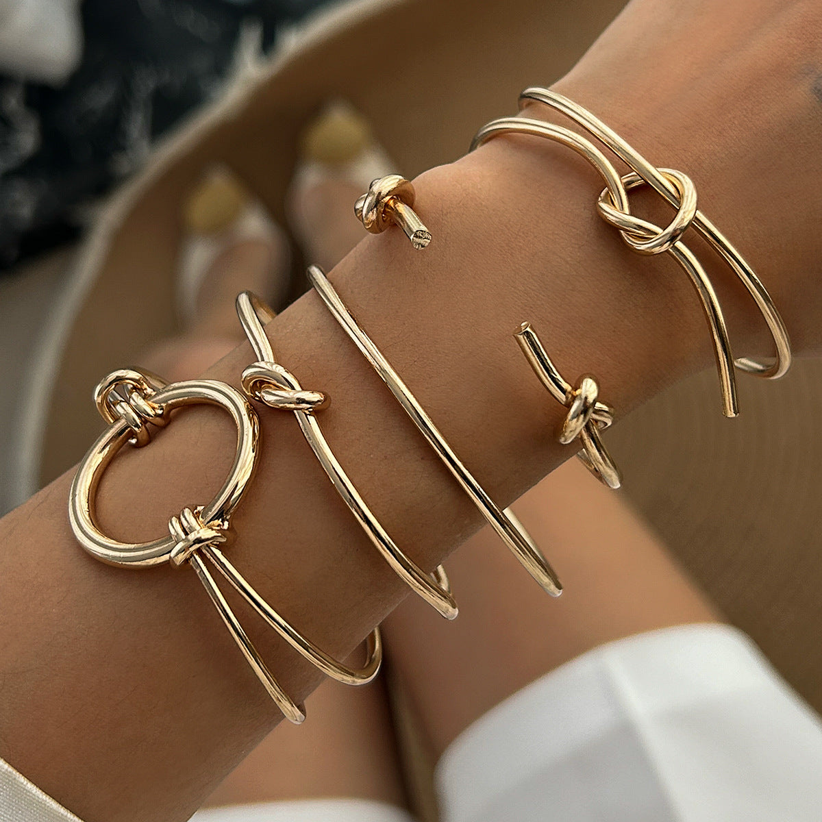 Brazalete abierto geométrico minimalista de doble capa con nudo hueco y acabado metálico chapado