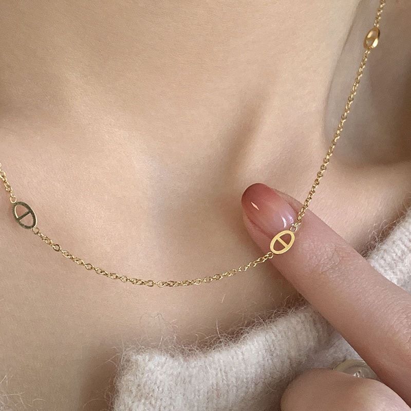 Collana con pendente a naso di maiale in acciaio al titanio placcato oro, tono freddo e minimalista, da donna, con catena a O e design che esalta le clavicole