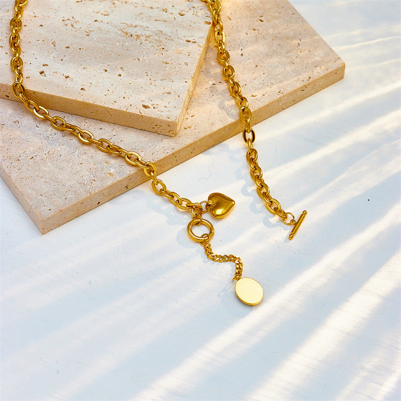 Collana con ciondolo ovale minimalista in acciaio titanio con dettaglio nappa e chiusura OT a forma di cuore