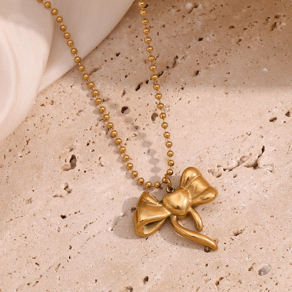 Collana con ciondolo a fiocco alla moda da donna in acciaio inossidabile con placcatura in oro 18 carati su catena di perline rotonde