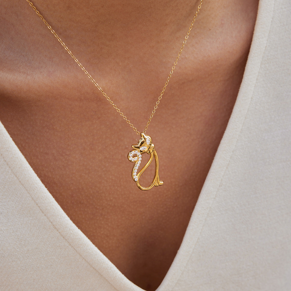 Elegante collar con colgante de gato en acero de titanio con incrustaciones de diamantes de imitación y chapado de oro PVD para mujer