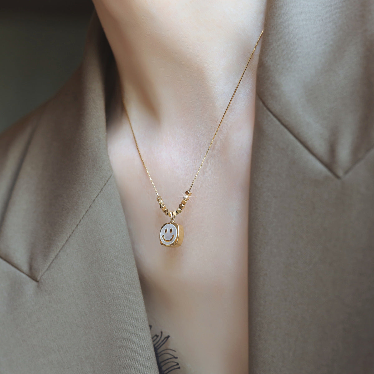 Collana con pendente a faccina sorridente minimalista da donna in acciaio al titanio con intarsio in madreperla e finitura placcata