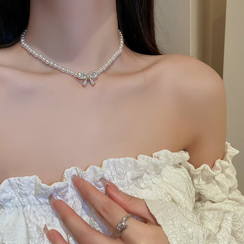 Elegante collar con colgante de lazo de diamantes de imitación y detalles de nácar perlado para mujer — Delicada cadena para clavícula en estilo de lujo minimalista y a la moda