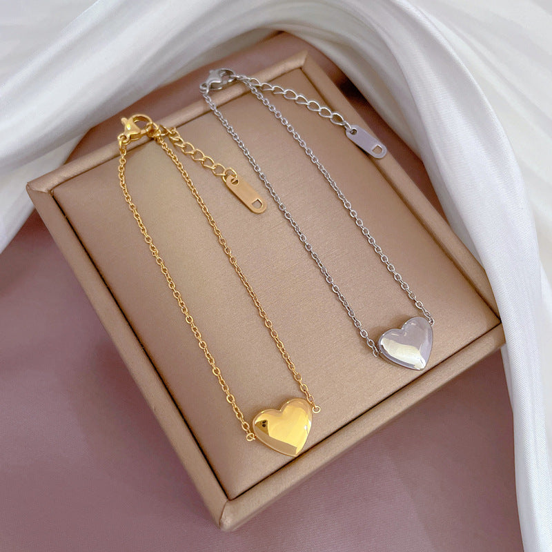 Bracciale a Cuore Minimalista in Acciaio al Titanio Tonalità Fredda per Donna con Intarsio Dorato e Texture Ondulata